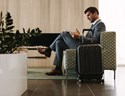 Businessman waiting for flight with suitcase